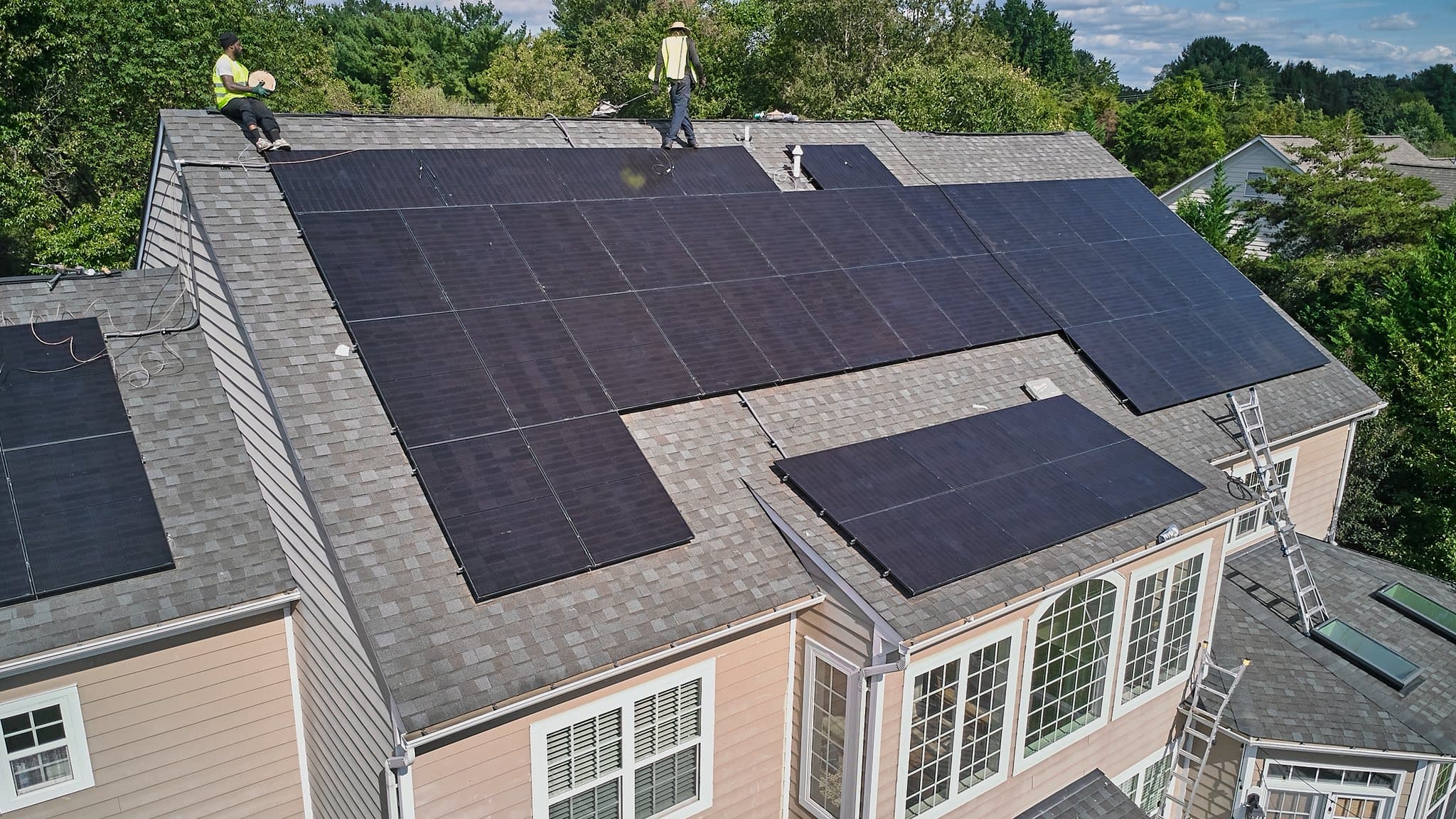 Aduu Solar team member inspecting rooftop solar panel installation